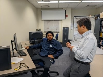 Bo Chen works with a visiting community college student in the security and privacy lab.