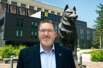 Andrew Barnard in front of the Husky Statue and H-STEM Complex.