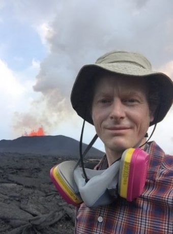 Simon Carn with an erupting volcano in the background.