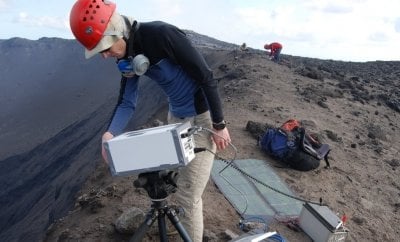 Simon Carn adjusting equipment at volcano site.