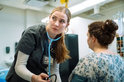 A nursing student taking someone's blood pressure.