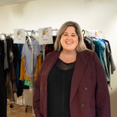 Alexandra Marshall standing in front of racks of clothing.