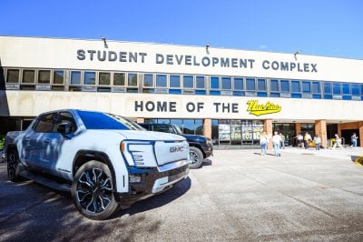 A white Silverado and a black Hummer parked outside the Student Development Complex.