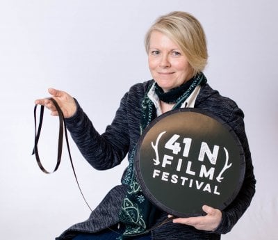 Erin Smith holding a large film reel with the 41N Film Festival logo.