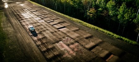 Vehicle driving on a bumpy and wet track in the woods.