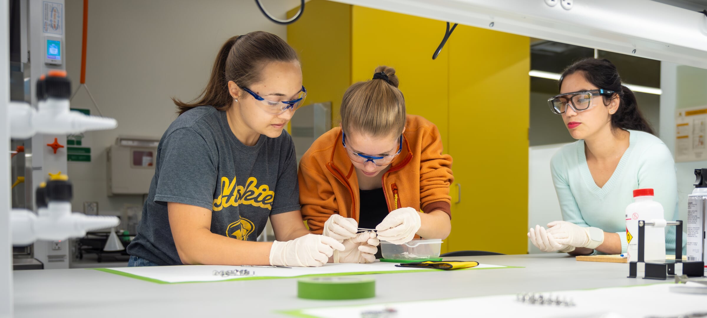 A pre-medical students performing a lab with while wearing personal protective equipment. 