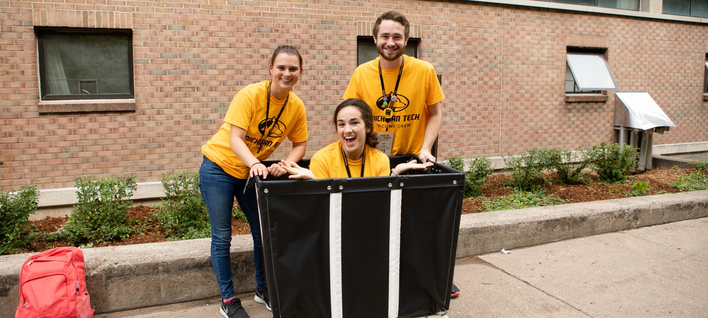 Move In Day volunteers with move in cart in front of residence hall 