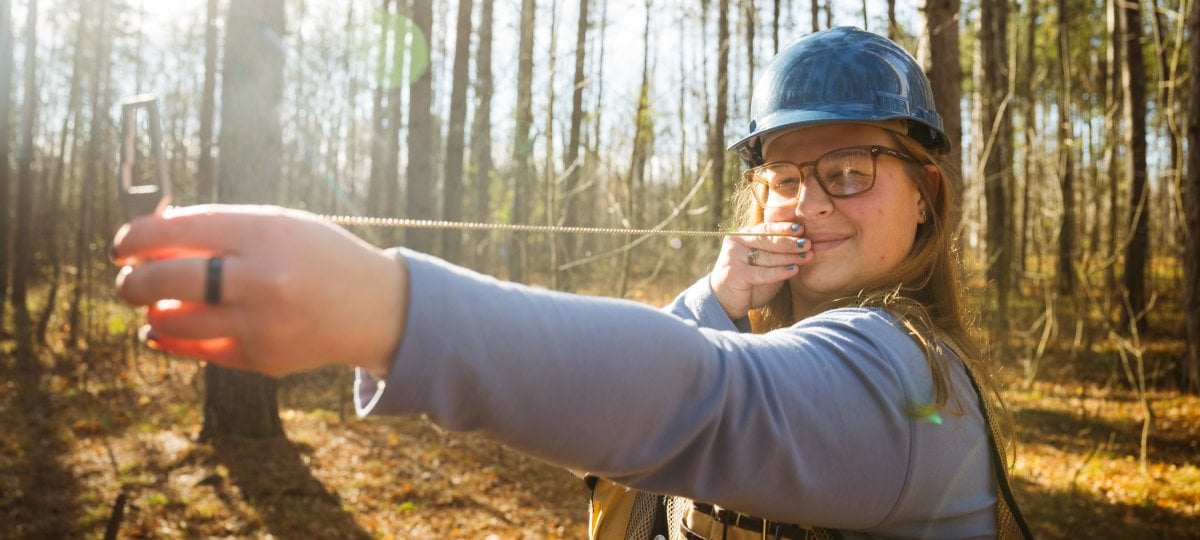 Veronica Blissick uses an angle gauge to measure trees along the Tech Trails.