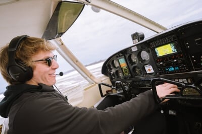 Austin Champine works the controls inside the cockpit of his single engine plane