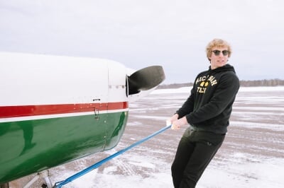 Austin Champine pulling his single engine plane out of the garage at Houghton County Memorial Airport.