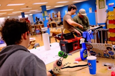 Copper Country Robotics team members work together on their robot prototype in the Alley Makerspace.