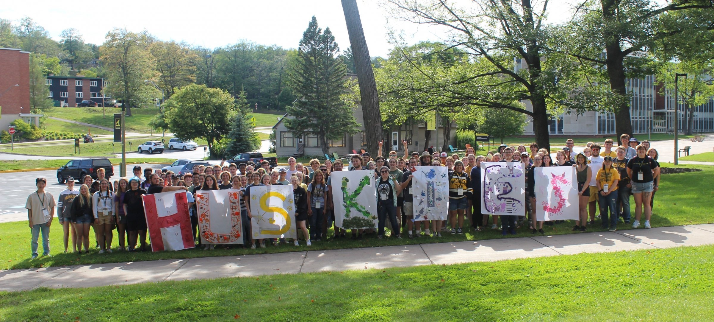 Michigan Tech students holding Huskies lettering