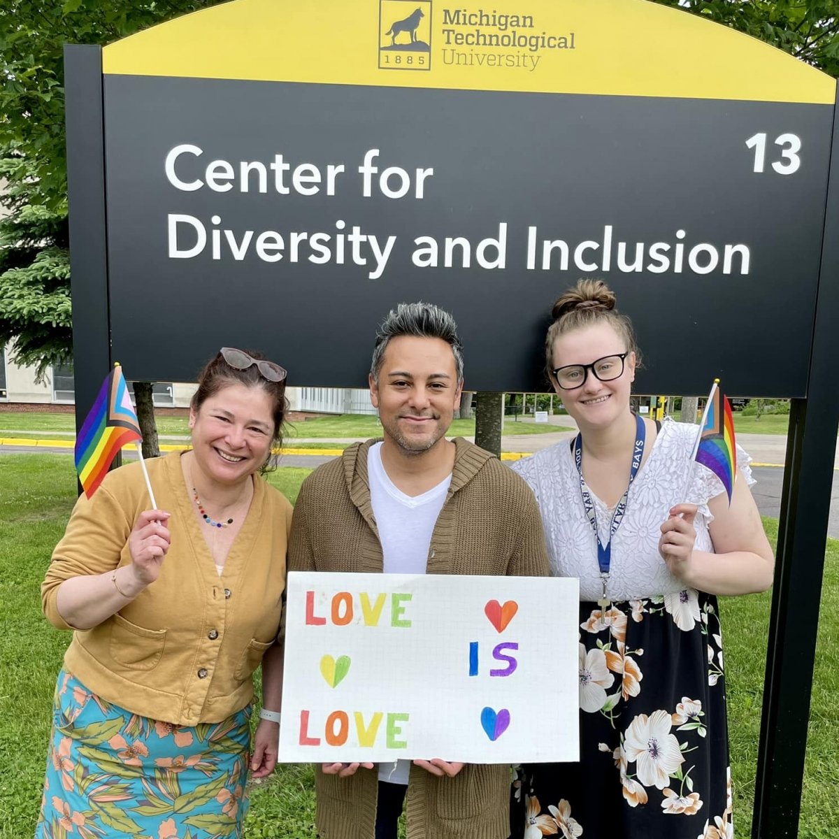 Love is Love sign with Student Affairs staff members