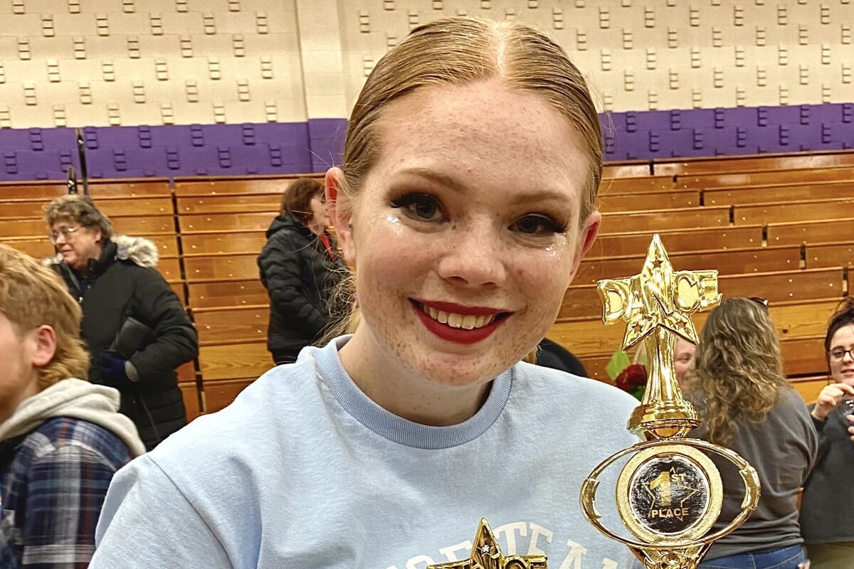 Student holding trophies after a Dance Team competition.