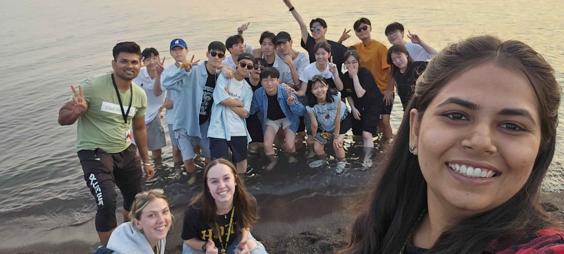 students and staff at the beach for sunset