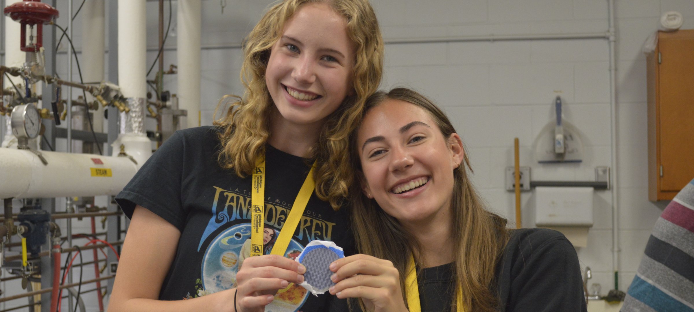 two young women smile in a lab