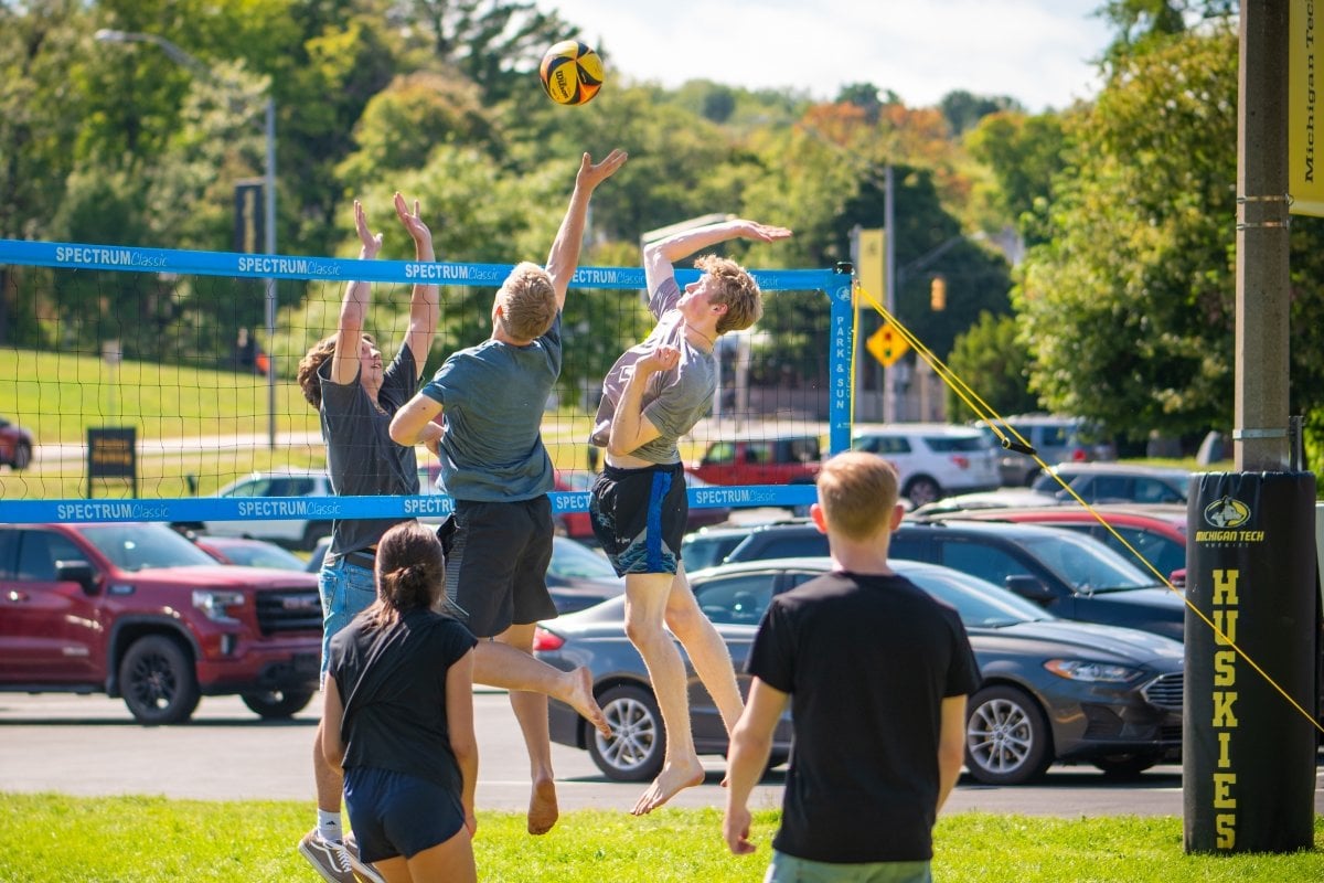 Students playing volleyball on campus.