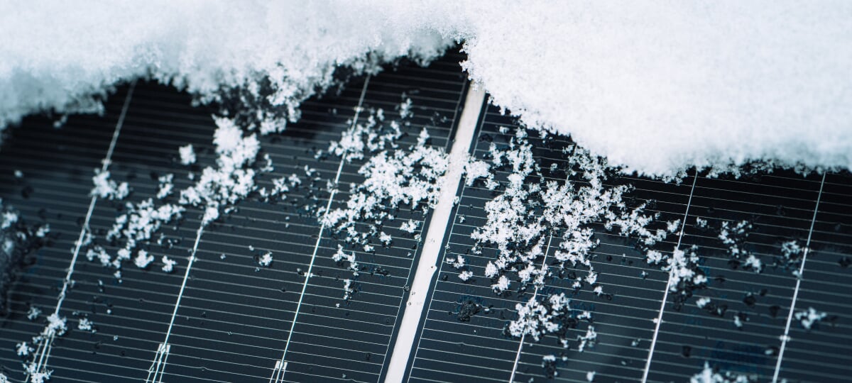 Close-up of snow covering most of a solar panel.