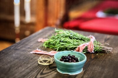 image of herbs and berries (in a bowl) on a wooden table