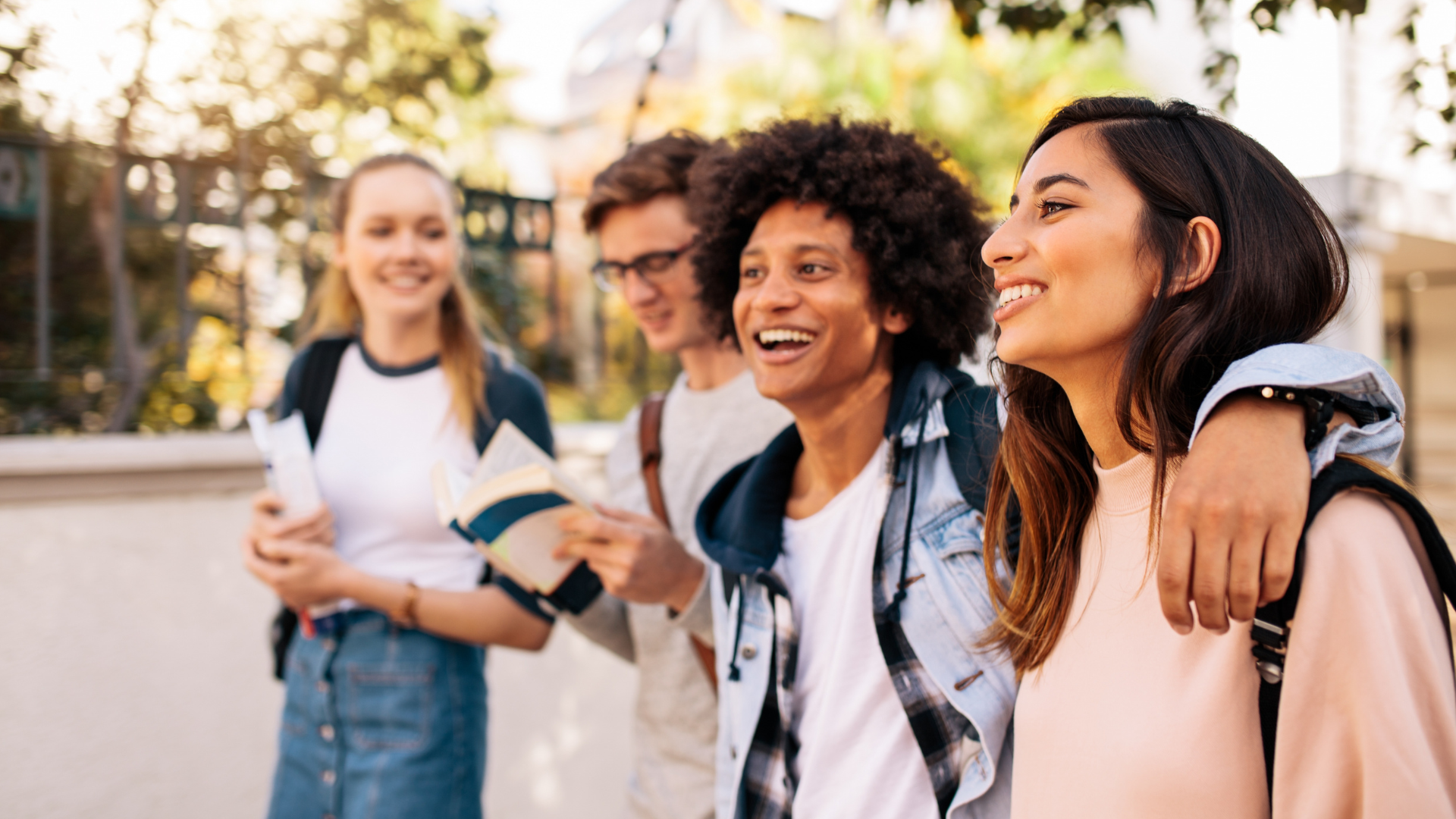 Four students walking and laughing